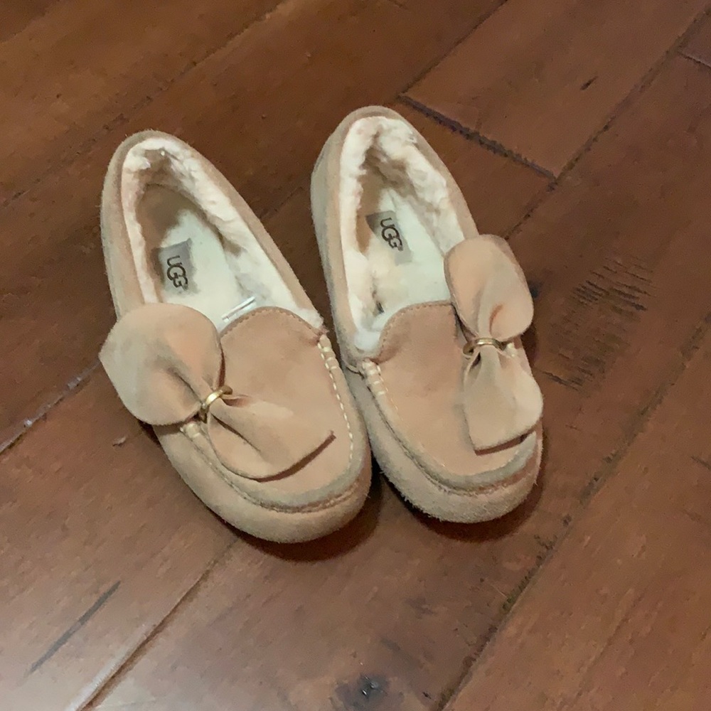 Pink fuzzy slippers from Ugg with a big bow on top